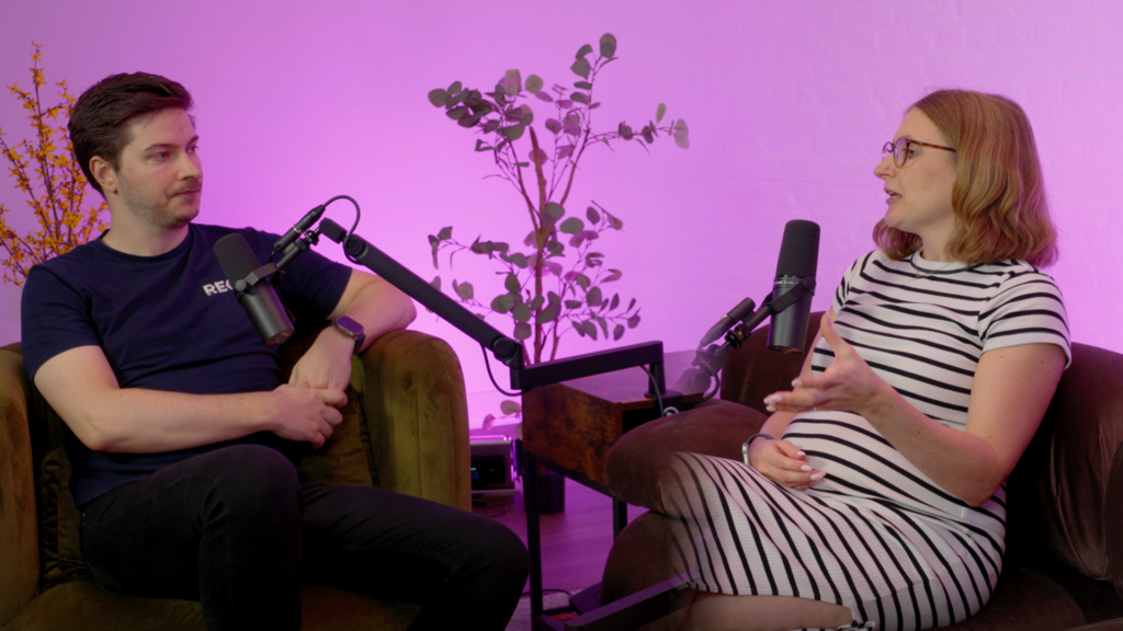 Matt Maidment of REO Digital and Katie Bloor from Optimizley recording the Beyond Conversion podcast, seated on a sofa against a pink backdrop.